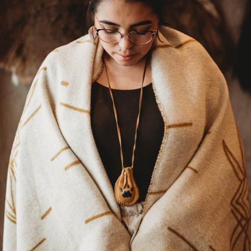 Samantha wrapped in a blanket with a medicine pouch around her neck